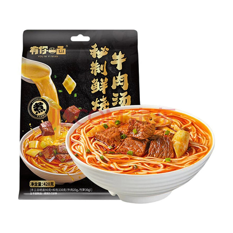 有你一面秘制鲜烧牛肉汤面包装袋及一碗盛满牛肉块、笋片和葱花的成品面条。