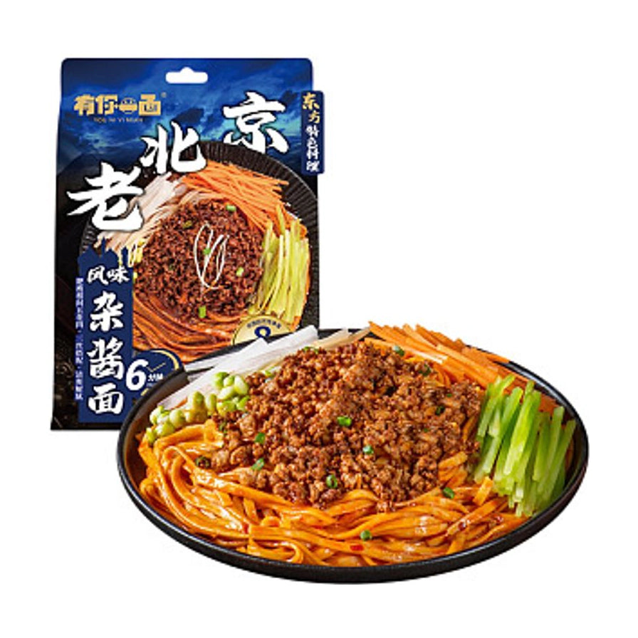 有你一面老北京风味杂酱面包装袋，前方摆放一碗拌好的杂酱面，配有黄瓜丝、胡萝卜丝和肉酱。
