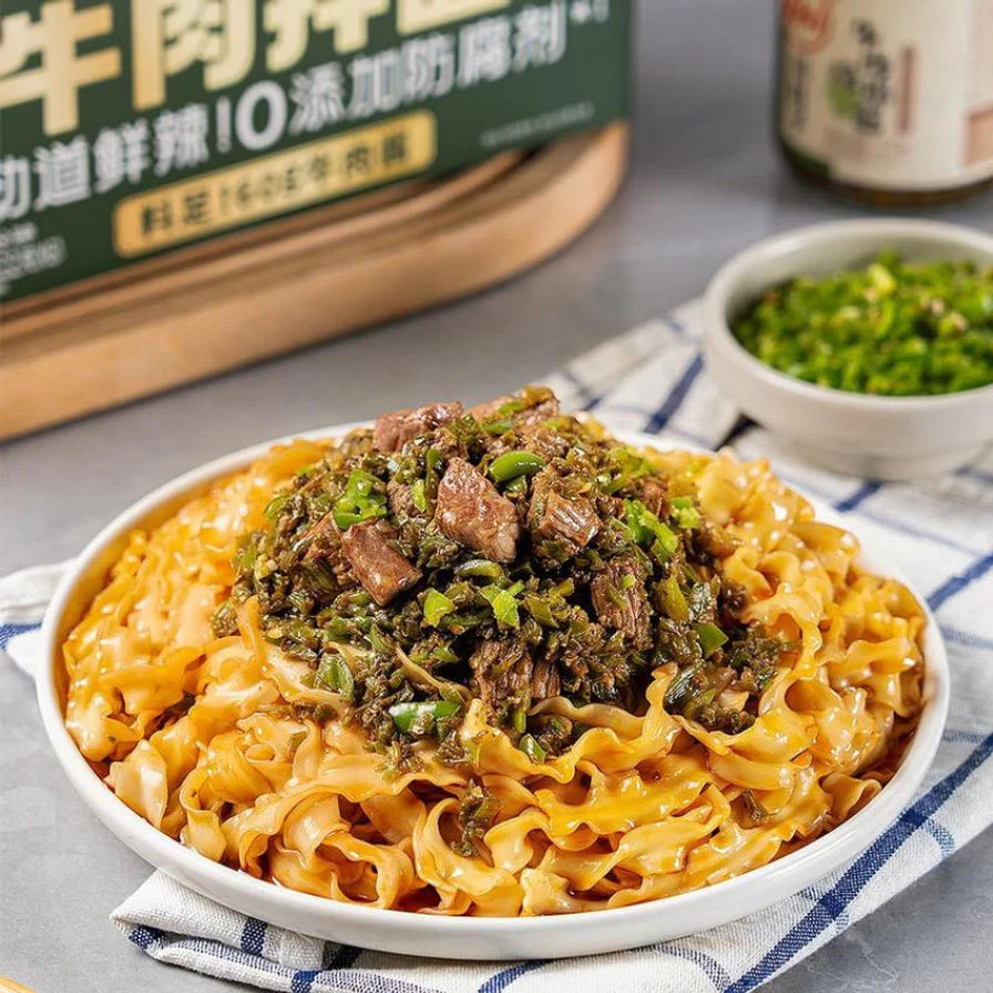 近距离拍摄的一碗有你一面烧椒牛肉拌面，面条宽厚，上面覆盖着满满的烧椒和牛肉粒。
