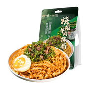 有你一面烧椒牛肉拌面包装袋与一碗拌好的面条，配有煎蛋和丰富的烧椒牛肉酱料。