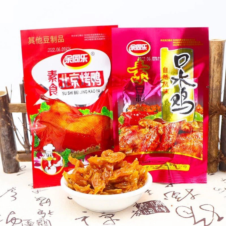 余同乐素食北京烤鸭味和口水鸡味两款包装并排展示，前方摆放一碗豆制品零食