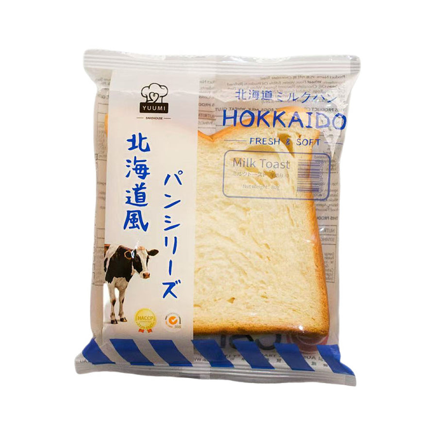 YUUMI 北海道风味吐司系列牛奶味，独立包装，包装袋上有奶牛图案，可见原色牛奶味吐司切片。