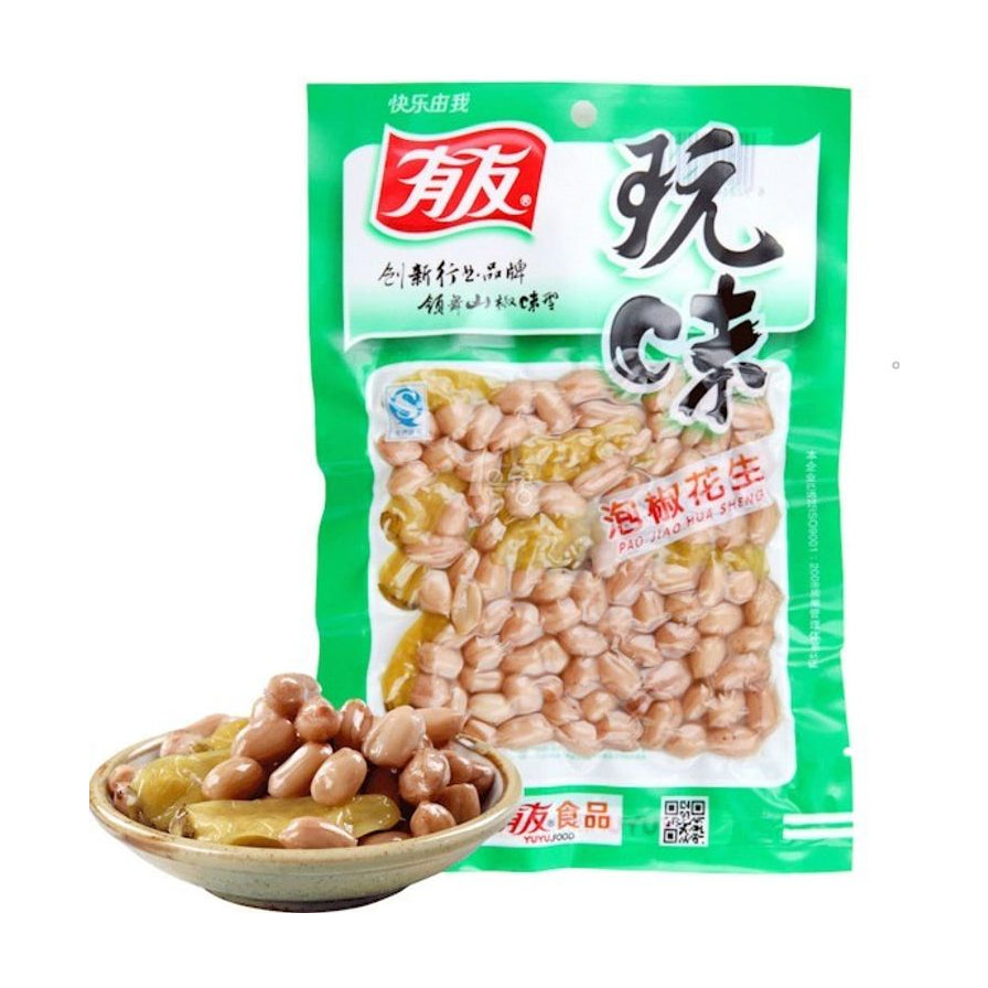 有友玩味泡椒花生绿色包装袋，前方摆放一小碟装满饱满花生和泡椒的实物图，展示爽脆质感。