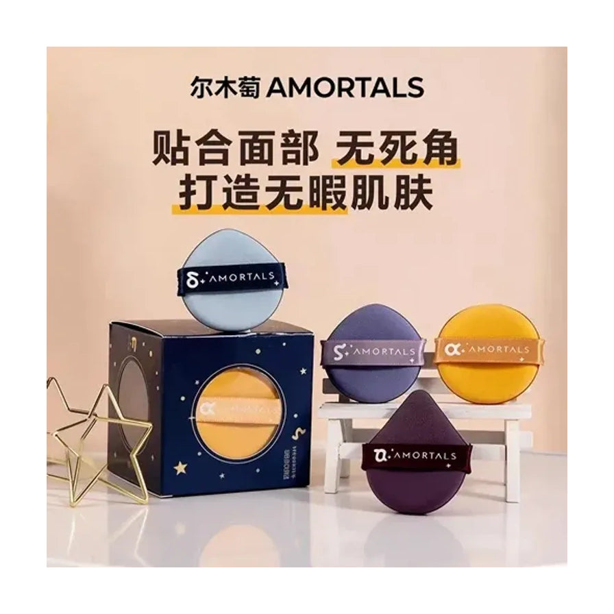 尔木萄 AMORTALS 粉扑场景图，配有中文宣传语“贴合面部 无死角”，展示多色粉扑与包装盒。