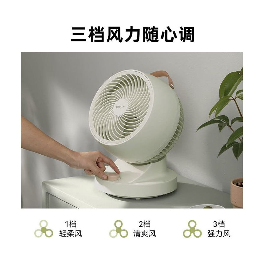 展示小熊空气循环扇的使用场景，一只手正在调节底座上的旋钮，上方配有“三档风力随心调”文字及不同档位的图标说明。