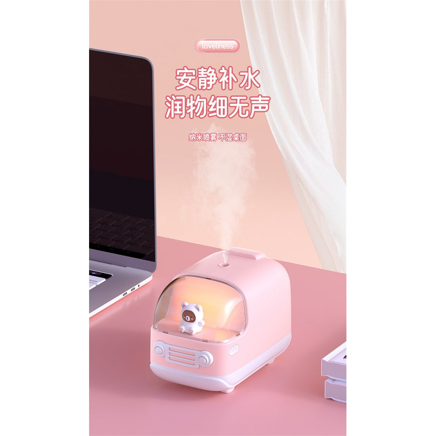粉色小熊巴士加湿器放置在办公桌电脑旁，展示静音补水功能，配有“安静补水 润物细无声”文字。