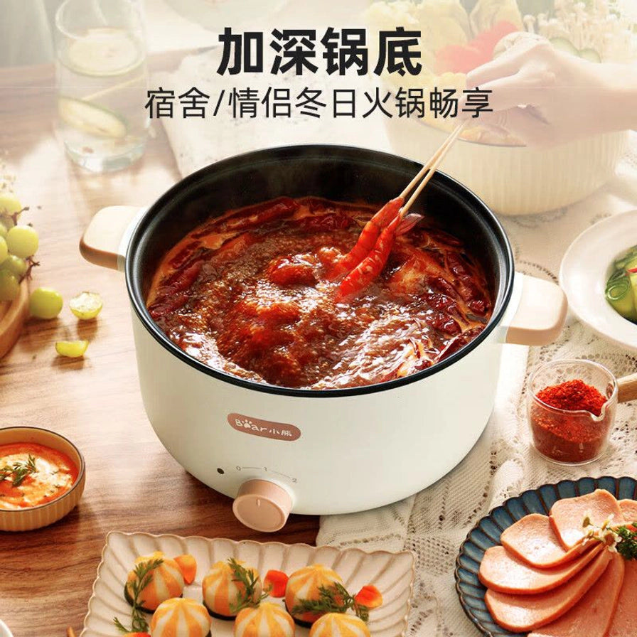 小熊电煮锅正在涮火锅的场景，展示加深锅底设计，适合宿舍或情侣冬日火锅畅享。