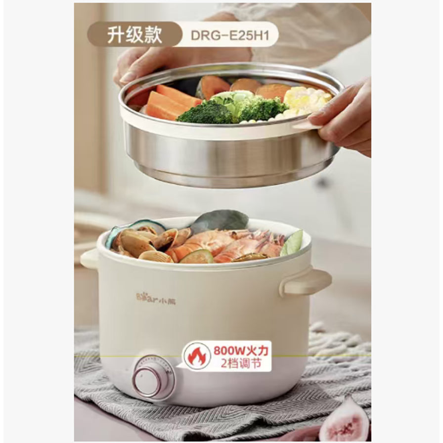 展示小熊电煮锅上蒸下煮功能，上方蒸屉装有蔬菜，下方锅内正在煮海鲜，标注800W火力及型号。