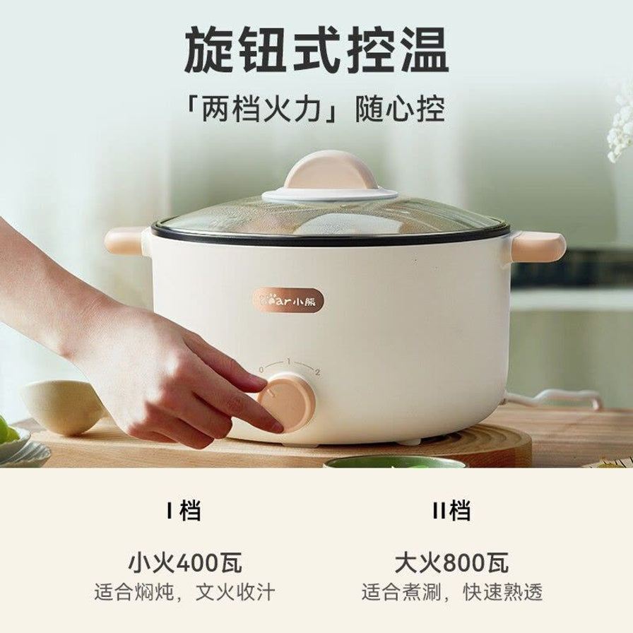 手部正在操作小熊电煮锅的旋钮，展示两档火力调节功能，下方配有 400W 小火和 800W 大火的文字说明。