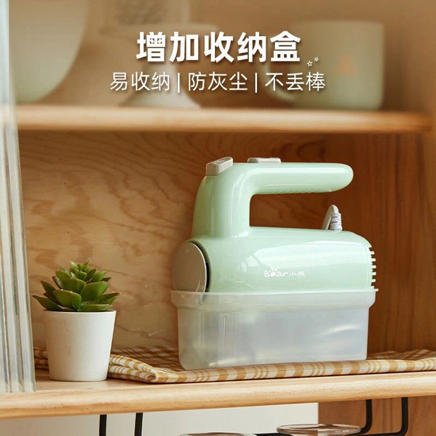 小熊电动打蛋器收纳在半透明底座中，放置在木质橱柜架子上，上方配有“增加收纳盒”中文说明。