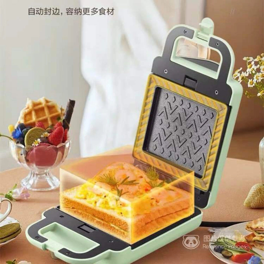 小熊三明治机在餐桌上的使用场景，展示大容量加深烤盘，可容纳厚实内馅，带有“自动封边，容纳更多食材”的文字说明。