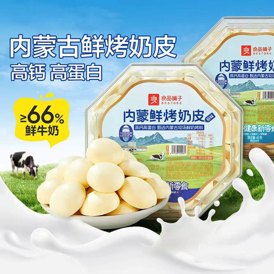 良品铺子内蒙古鲜烤奶皮宣传图，带有鲜牛奶含量大于等于66%的文字说明，背景为牧场和飞溅的牛奶。