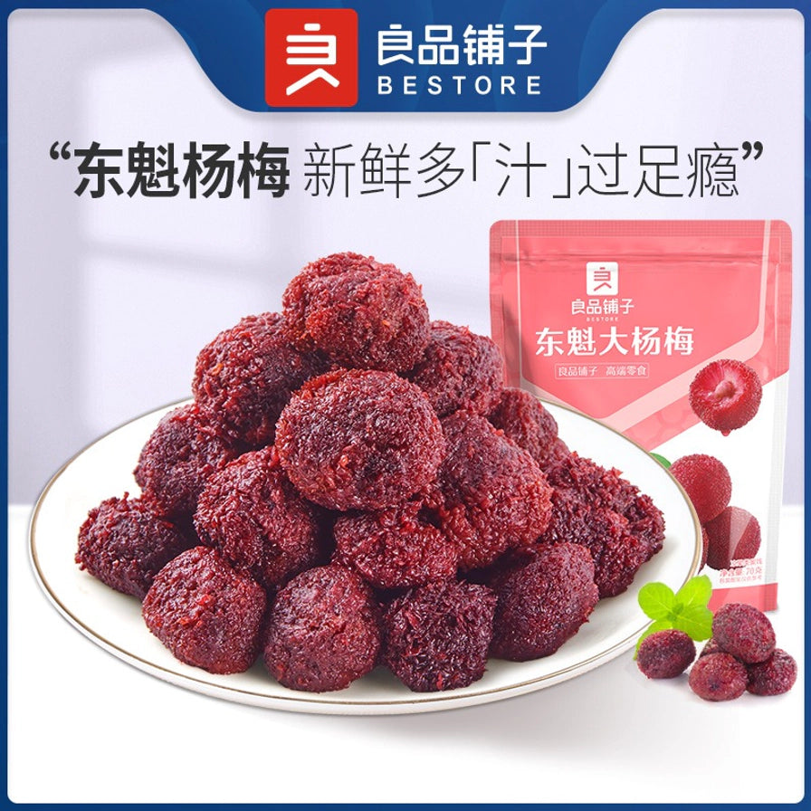 良品铺子东魁大杨梅宣传图，白色圆盘中堆叠着大量深红色杨梅干，背景带有“东魁杨梅 新鲜多汁过足瘾”字样及包装袋。