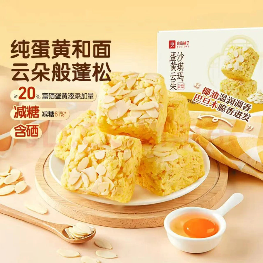 良品铺子蛋黄云朵沙琪玛宣传海报，展示纯蛋黄和面、减糖卖点及巴旦木脆片细节