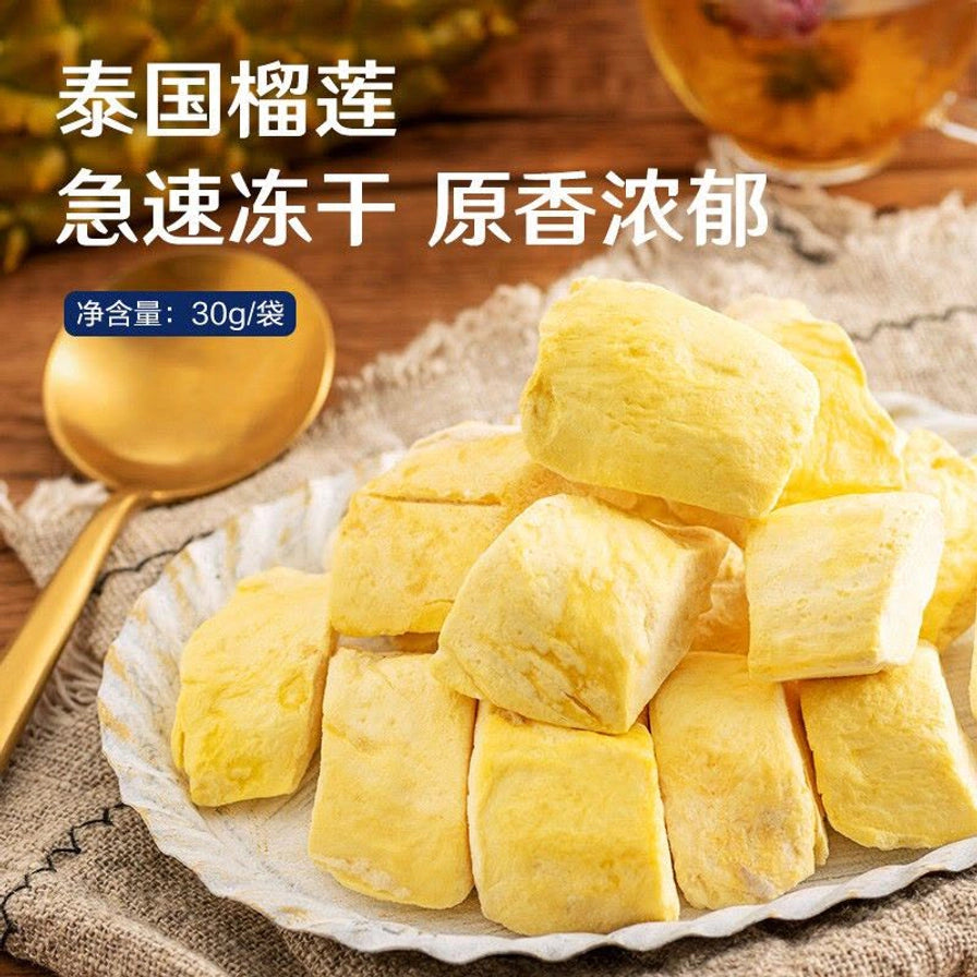堆叠在白盘中的良品铺子冻干榴莲干，背景有金色勺子，配文泰国榴莲急速冻干