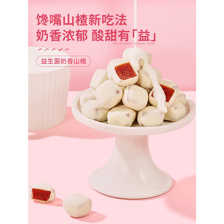 白色高脚甜品台上堆叠的益生菌奶香山楂，上方正在淋入浓郁乳液，背景为粉色，上方带有馋嘴山楂新吃法等宣传文字。