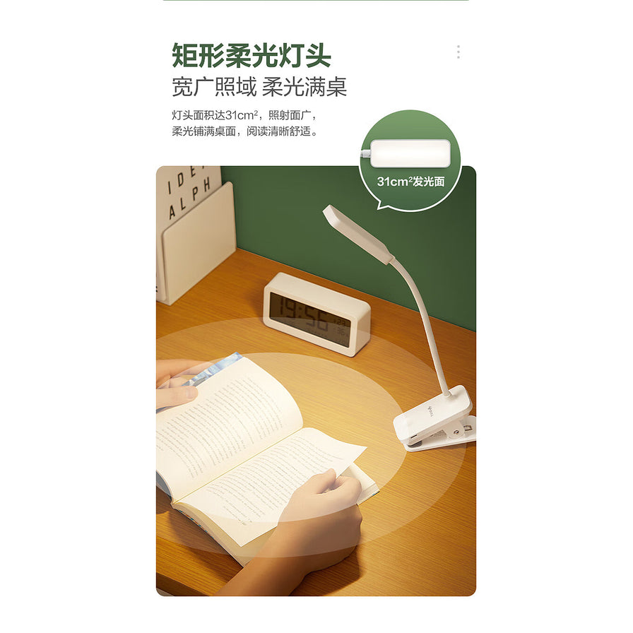 公牛护眼台灯在书桌上的使用场景，展示矩形柔光灯头带来的宽广照明区域，光线均匀覆盖书籍。