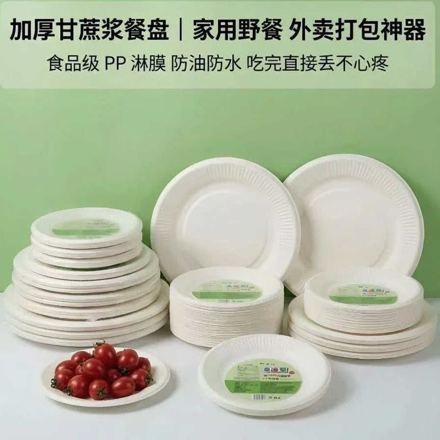 多组不同尺寸的一次性环保纸碗和纸盘堆叠展示，背景带有中文卖点说明，前景有一盘圣女果。