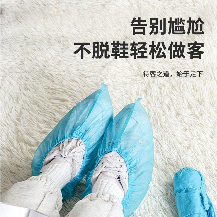 一个人穿着蓝色无纺布鞋套踩在白色地毯上，上方配有“告别尴尬，不脱鞋轻松做客”的文字。