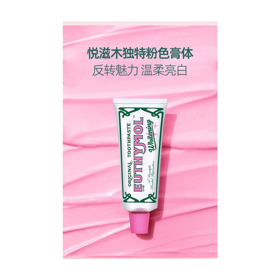 Euthymol 悦滋木粉色亮白牙膏管身展示，背景为粉色膏体纹理，上方配有中文说明文字。