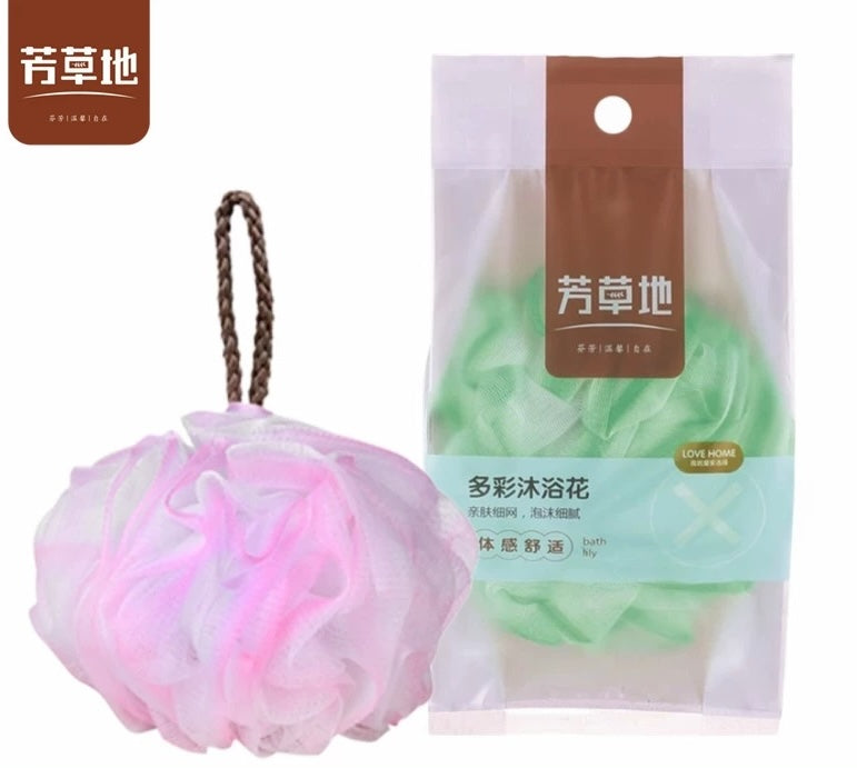 芳草地多彩沐浴花实物展示，包含粉色散开浴球与绿色袋装产品，包装印有品牌及卖点信息。