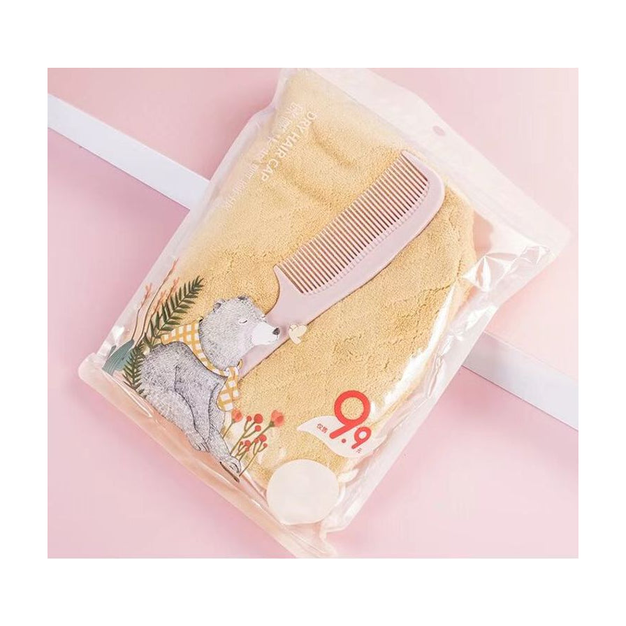 粉色背景上斜放的干发帽梳子套装，包装袋印有小熊插画，右下角带有9.9元价格标签。