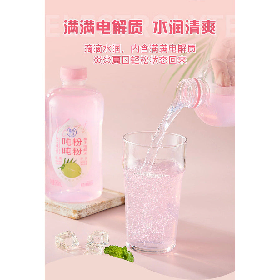 正在将盒马吨吨粉粉椰子电解水倒入玻璃杯中，上方带有满满电解质水润清爽的宣传文字。