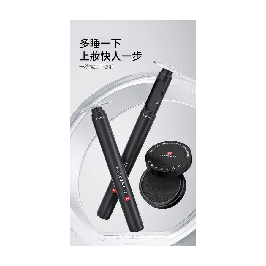 两支黑色假睫毛印章笔与圆形墨盒在透明托盘上的特写，背景带有中文宣传标语。