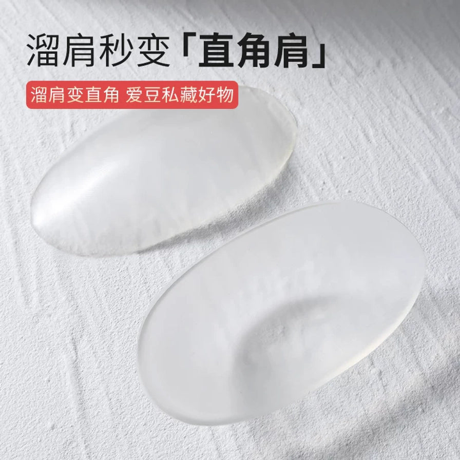 放置在白色纹理背景上的透明肩垫，上方配有溜肩秒变直角肩的文字说明。