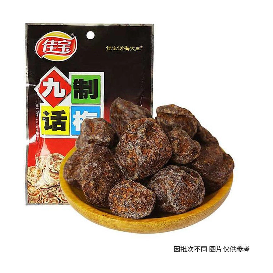 佳宝九制话梅肉包装袋，前方木碗中盛满深褐色、果肉厚实的话梅，右下角带有因批次不同图片仅供参考的说明文字。