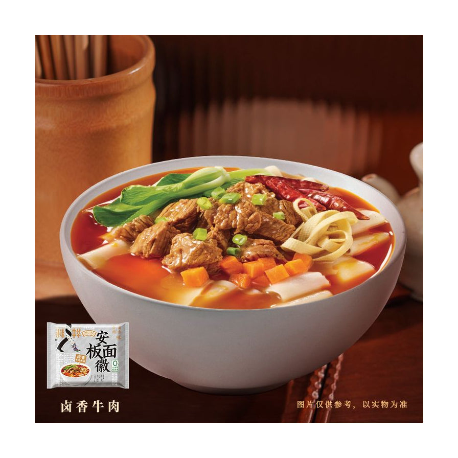 一碗热气腾腾的今麦郎安徽板面，配有牛肉块、青菜、辣椒和宽面，背景为木质餐具，左下角有单袋包装图。