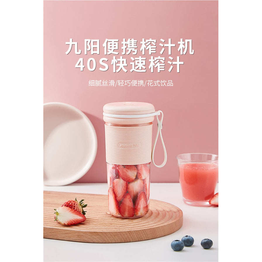 九阳便携榨汁机场景图，粉色背景，展示40秒快速榨汁功能，桌面上摆放着草莓、蓝莓和一杯鲜榨果汁。