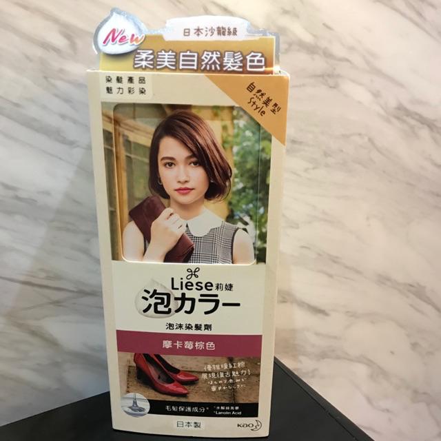 花王 Liese 泡沫染发剂实物拍摄图，包装顶部贴有中文卖点标签，背景为大理石纹理台面。