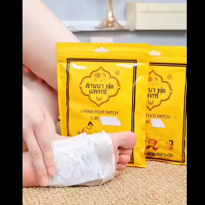 用户将白色草本足贴敷在脚底的使用场景，背景摆放两包黄色兰纳足贴产品
