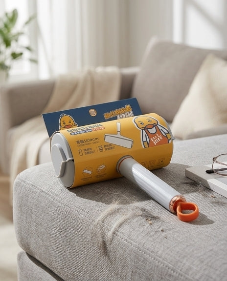 萌鸭粘毛滚筒使用场景示意图，展示在衣物上滚动去除毛发和灰尘的效果。