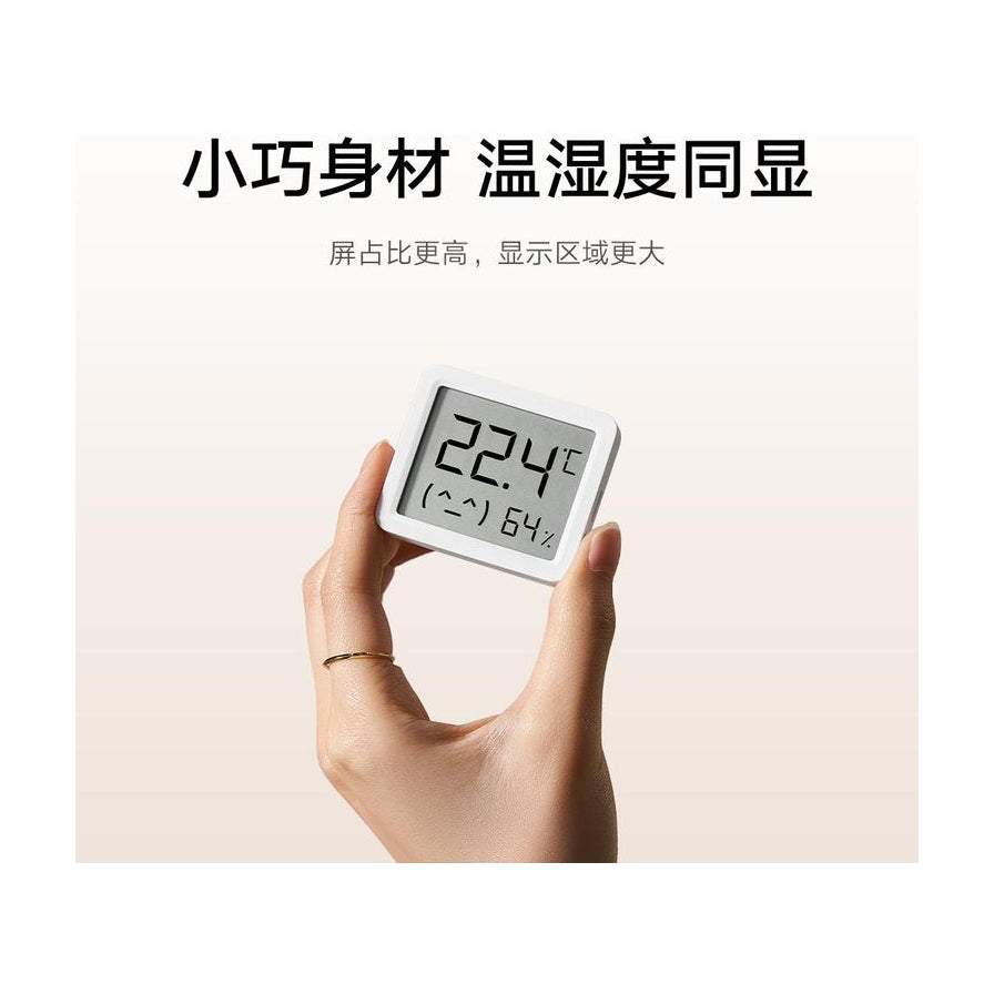 单手捏住小米米家智能温湿度计3，展示其小巧的机身尺寸，上方配有“小巧身材 温湿度同显”的中文卖点文字。