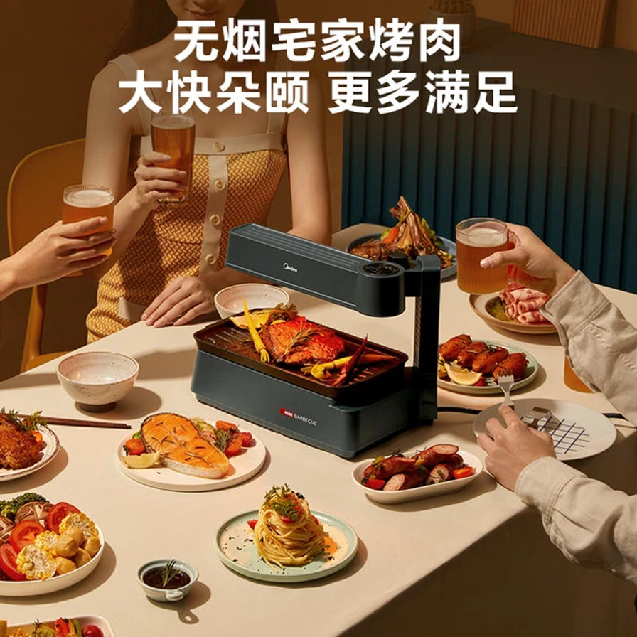室内聚餐场景图，展示在餐桌上使用美的无烟电烤盘进行烤肉，周围摆放着各种食材。