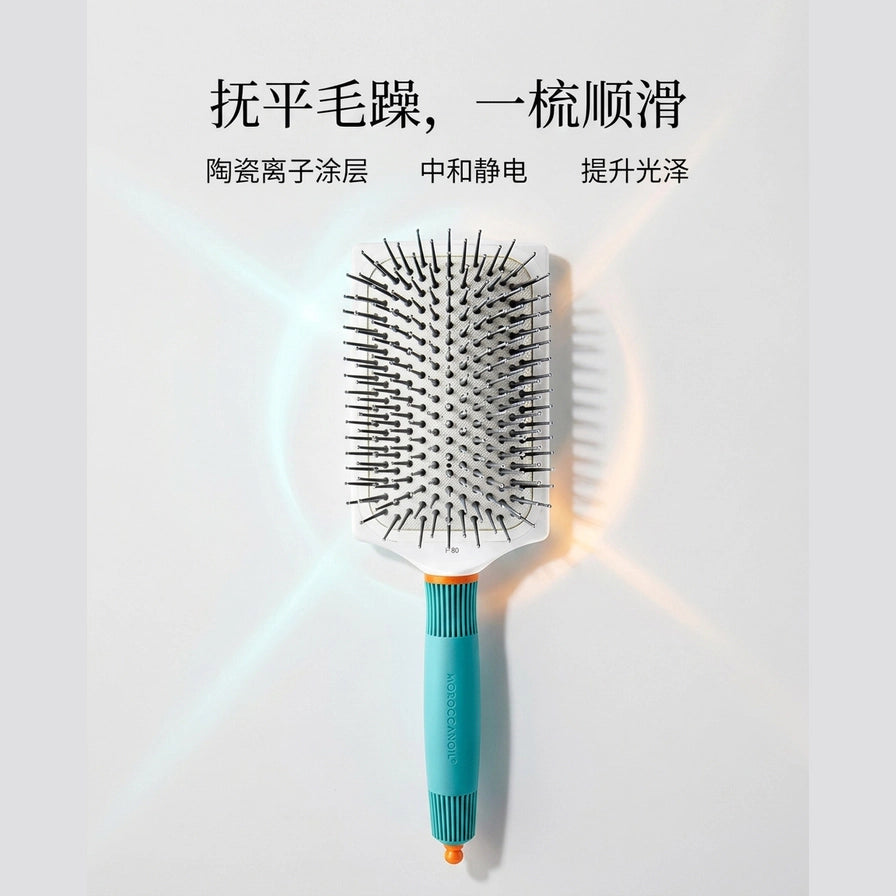 Moroccanoil 气垫梳营销渲染图，背景带有光效，顶部配有抚平毛躁和陶瓷离子涂层等中文宣传文案。