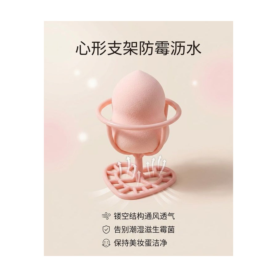 带有中文说明的美妆蛋支架功能演示图，图解心形底座防霉沥水与通风透气特性。