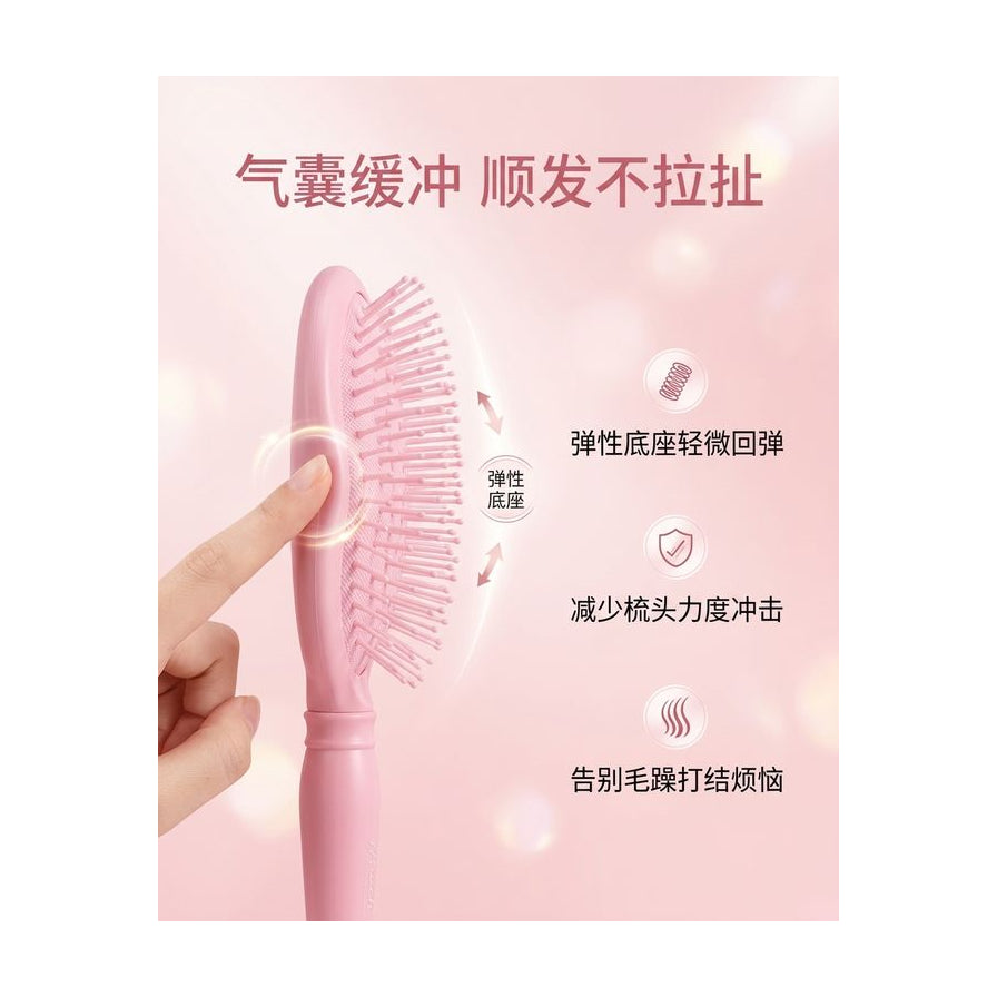手指按压粉色梳子展示气囊回弹效果，配有中文卖点标注说明弹性底座与护发功能。