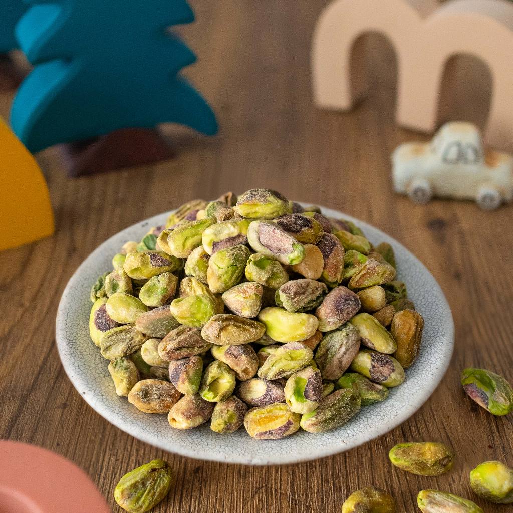 堆叠的无壳开心果仁特写，呈现自然鲜绿色泽与酥脆纹理，适合烘焙或直接食用。