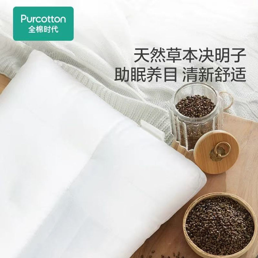 全棉时代决明子助眠枕局部特写，旁边摆放着装有天然决明子颗粒的玻璃罐和木碗，配有“天然草本决明子 助眠养目 清新舒适”文字。
