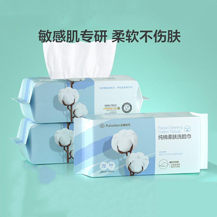 全棉时代洗脸巾多包堆叠展示图，顶部抽出一张白色棉柔巾，上方配有中文宣传标语。