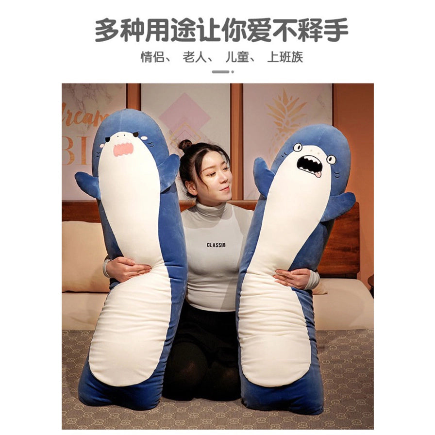 模特在卧室床上抱着两款不同表情的蓝色长条鲨鱼抱枕，上方配有多种用途让你爱不释手的中文卖点文字。