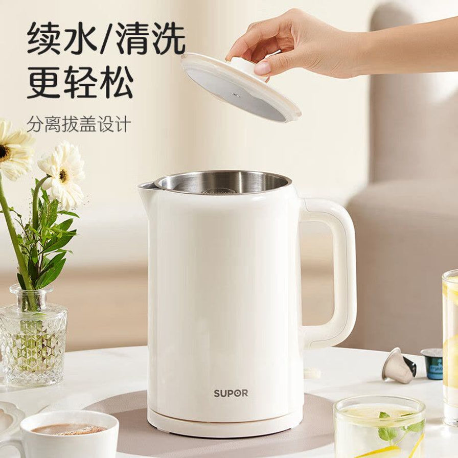 在生活场景中展示苏泊尔电水壶，一只手正在提起分离式壶盖，展示304不锈钢内胆，旁边配有咖啡和花瓶。