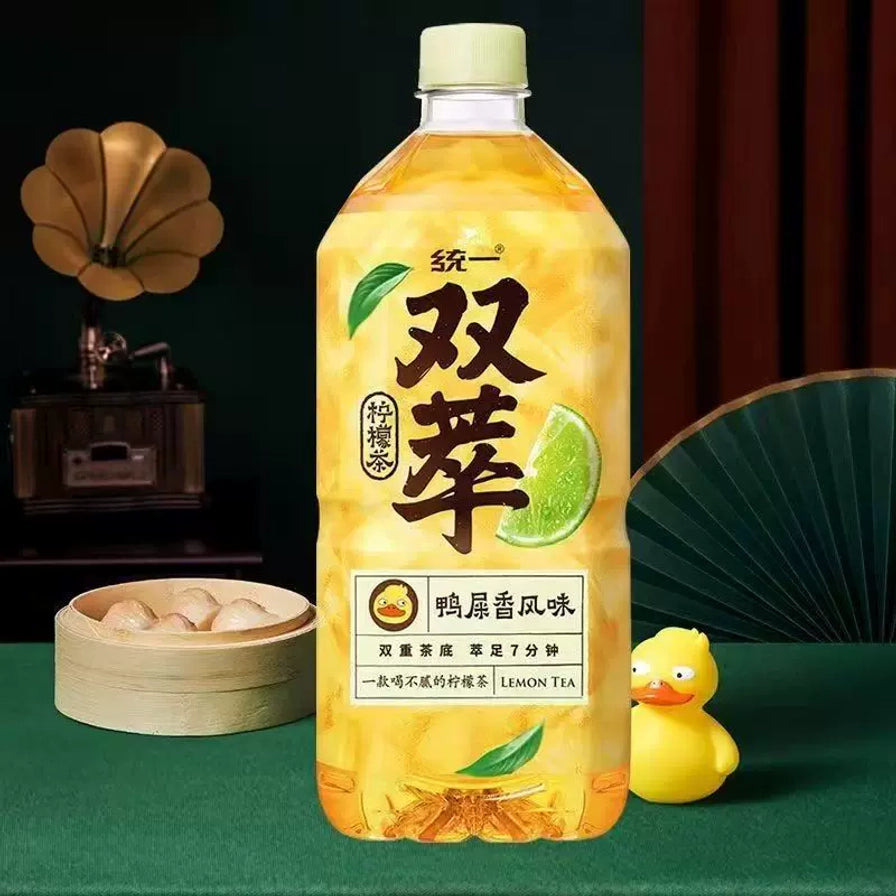 统一双萃柠檬茶鸭屎香风味1L大瓶装，背景配有中式茶点和装饰。
