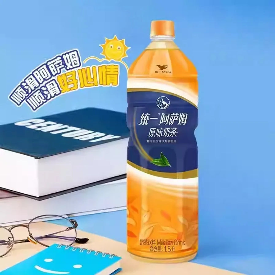 统一阿萨姆奶茶1.5L大瓶装，背景配有书籍、眼镜和笔记本，左上角带有顺滑好心情艺术字样。