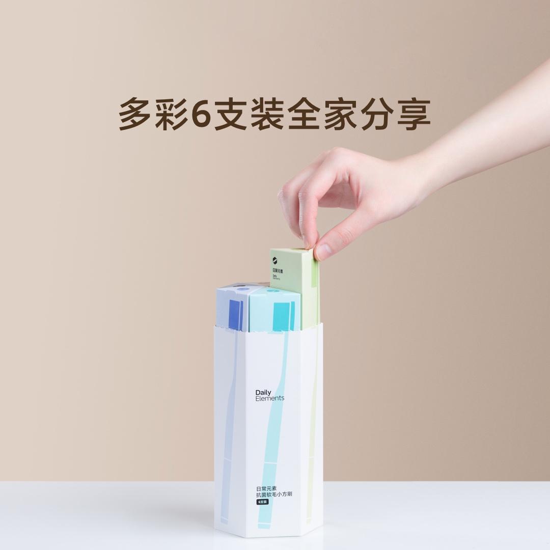 手部从包装盒中取出单支牙刷，背景含中文宣传文案多彩 6 支装全家分享