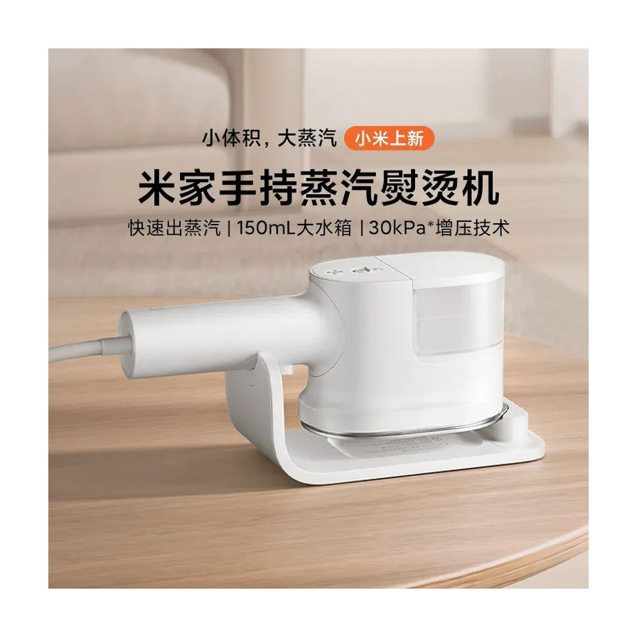 米家手持蒸汽挂烫机放置在木质桌面，上方配有产品卖点文字说明。