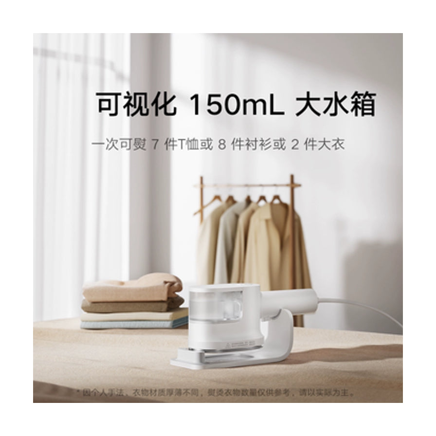 小米挂烫机放置在桌面上，背景为晾晒的衣物，上方文字强调150ml可视化大水箱容量。
